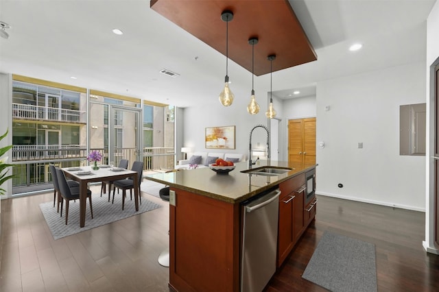 kitchen with pendant lighting, sink, an island with sink, stainless steel appliances, and dark hardwood / wood-style flooring