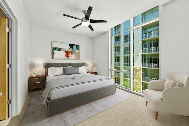 carpeted bedroom featuring floor to ceiling windows and ceiling fan