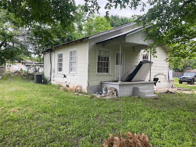 exterior space with central AC and a front yard