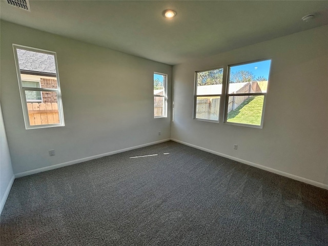 spare room featuring dark colored carpet