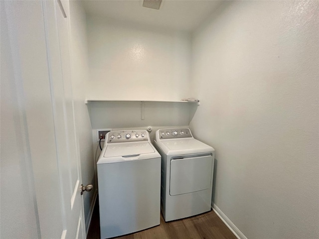 laundry room with independent washer and dryer and dark hardwood / wood-style floors