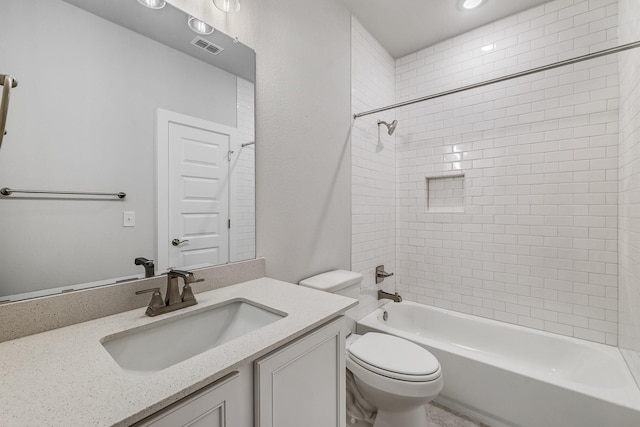 full bathroom with toilet, vanity, and tiled shower / bath