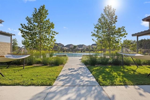 view of property's community with a pool and a yard