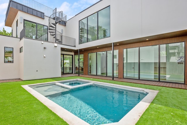 exterior space featuring a swimming pool with hot tub and a yard