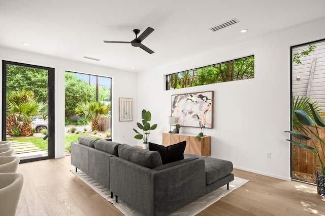 living room with light hardwood / wood-style flooring and ceiling fan