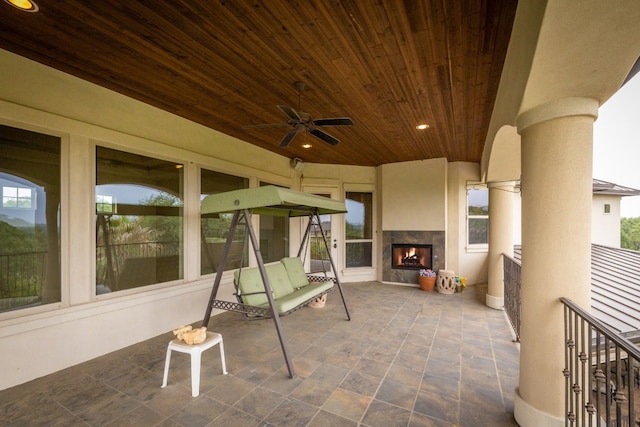 view of patio / terrace featuring a ceiling fan and a multi sided fireplace