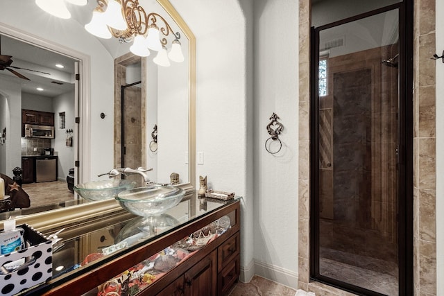 bathroom featuring a ceiling fan, a stall shower, baseboards, and double vanity