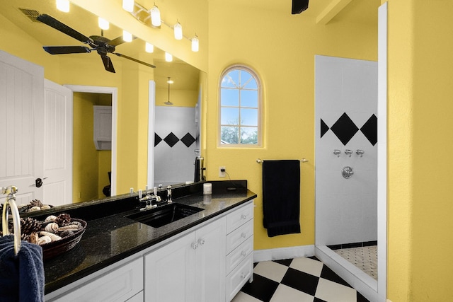 full bath with baseboards, ceiling fan, tile patterned floors, vanity, and a shower stall