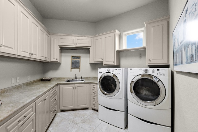 clothes washing area featuring cabinet space, a sink, and separate washer and dryer