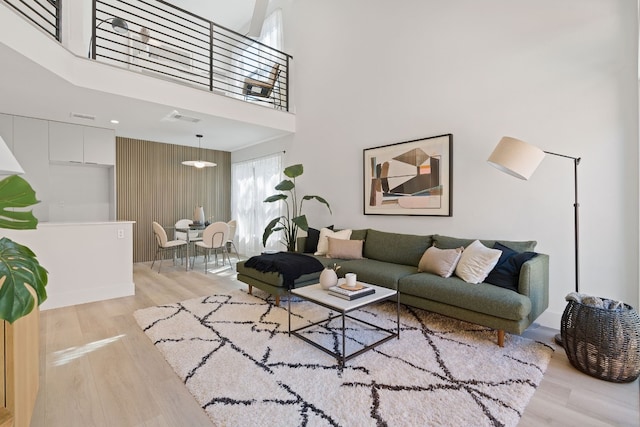 living room featuring light hardwood / wood-style floors and a high ceiling