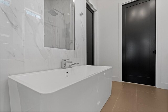 bathroom with tile patterned flooring, tile walls, and independent shower and bath