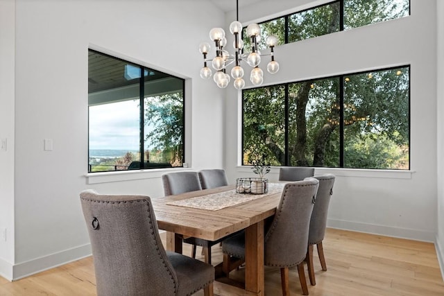 dining room with a wealth of natural light, a notable chandelier, and light hardwood / wood-style floors