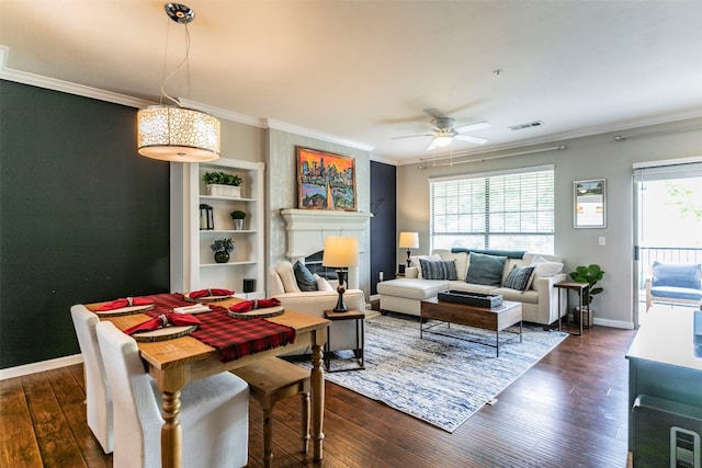 living room featuring dark hardwood / wood-style floors, ceiling fan, built in shelves, and ornamental molding