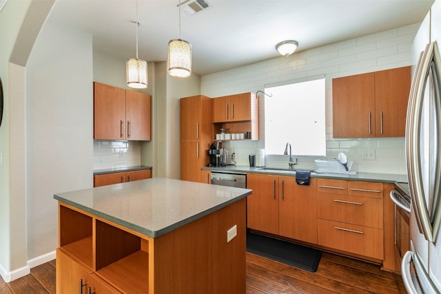 kitchen featuring decorative light fixtures, a kitchen island, tasteful backsplash, dark wood-type flooring, and sink