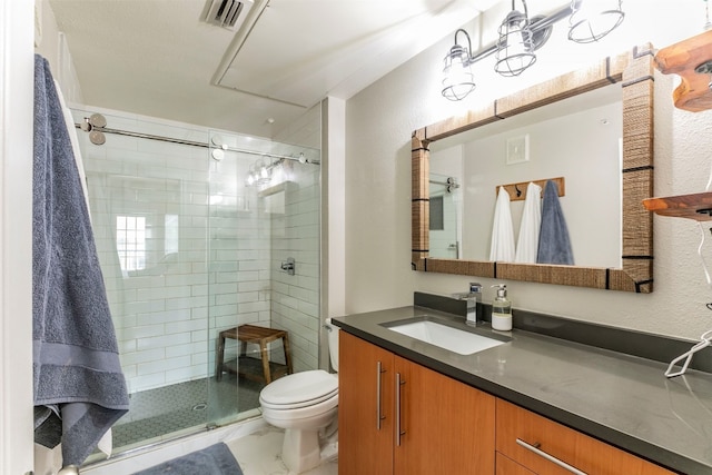 bathroom featuring vanity, toilet, and a shower with shower door