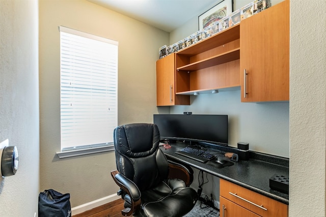 office space featuring built in desk and dark hardwood / wood-style flooring