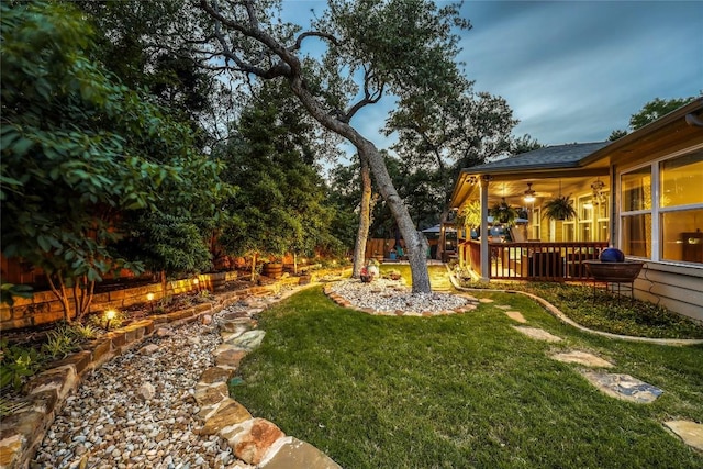 view of yard featuring ceiling fan and a deck