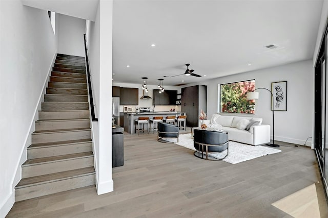 living room with ceiling fan and light hardwood / wood-style floors