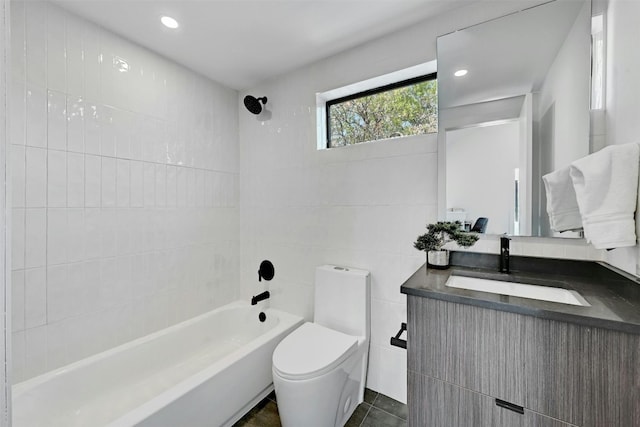 full bathroom featuring tile walls, tile patterned flooring, vanity, toilet, and tiled shower / bath