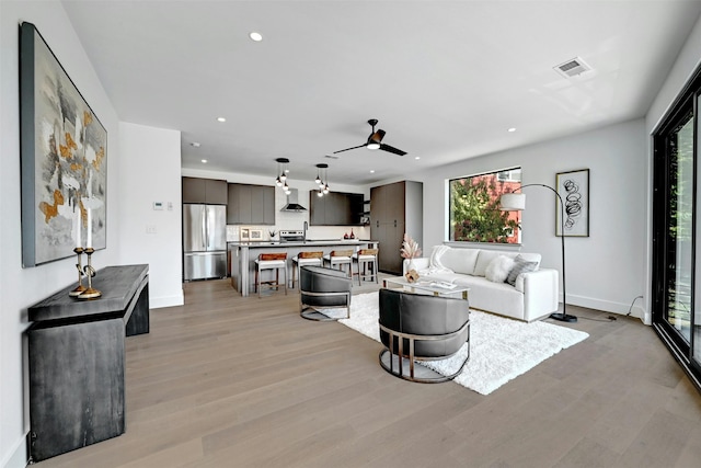 living room featuring ceiling fan and light hardwood / wood-style floors