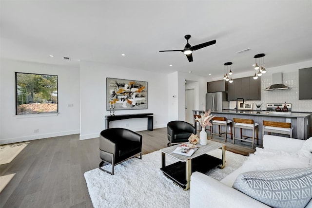 living room featuring sink, ceiling fan, and light hardwood / wood-style flooring