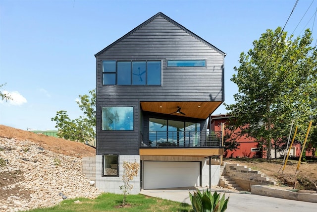 contemporary house featuring ceiling fan, a balcony, and a garage