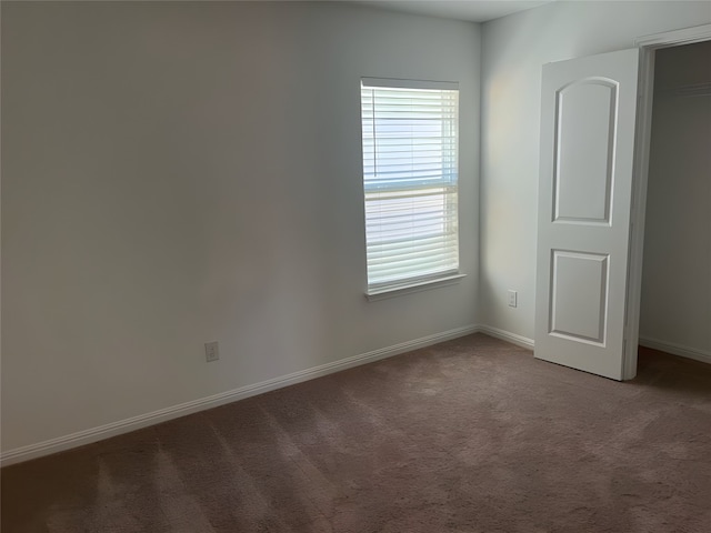 spare room with dark carpet