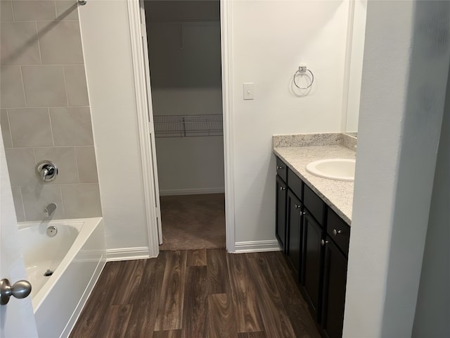 bathroom featuring hardwood / wood-style floors, vanity, and tiled shower / bath combo