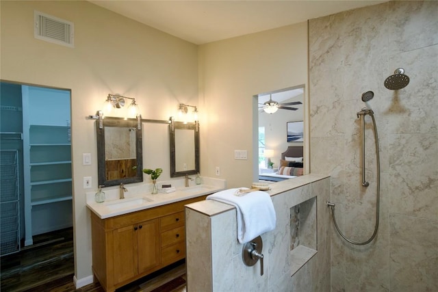 bathroom with vanity, ceiling fan, wood-type flooring, and tiled shower