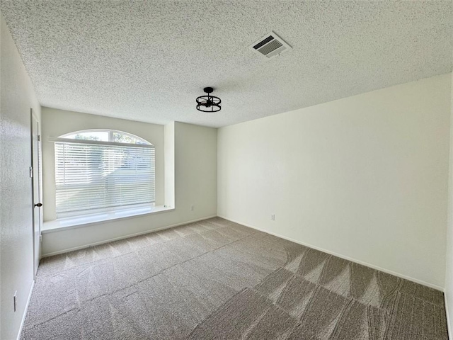 carpeted empty room with a textured ceiling