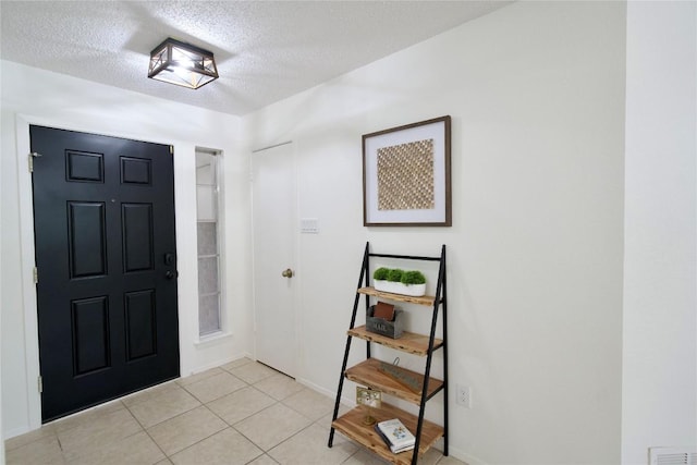 tiled entryway with a textured ceiling