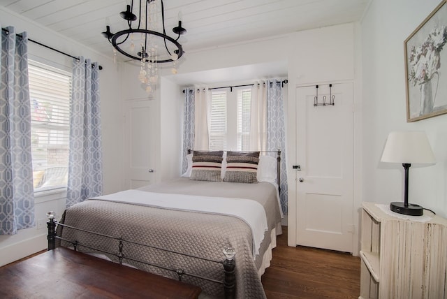 bedroom with ornamental molding, dark hardwood / wood-style flooring, a notable chandelier, and multiple windows