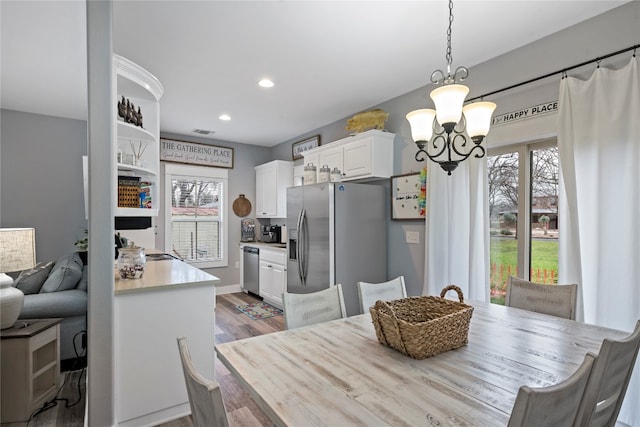 dining area with wood-type flooring and an inviting chandelier