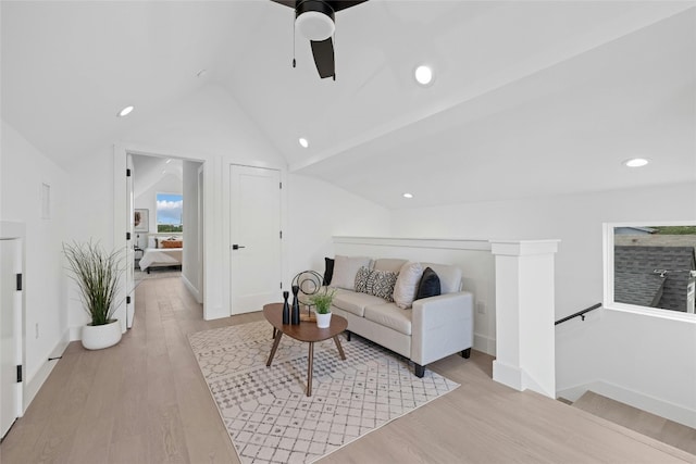 living room with ceiling fan, light hardwood / wood-style floors, and lofted ceiling