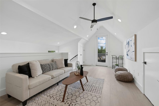 living room featuring ceiling fan, light hardwood / wood-style floors, and lofted ceiling