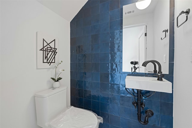 bathroom featuring sink, toilet, and lofted ceiling