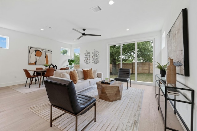 living room featuring ceiling fan, a wealth of natural light, and light hardwood / wood-style flooring