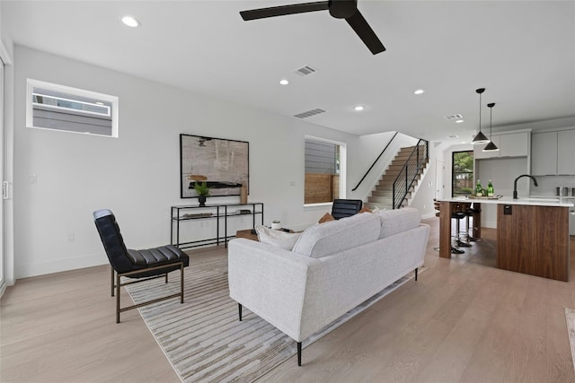 living room featuring ceiling fan and light wood-type flooring