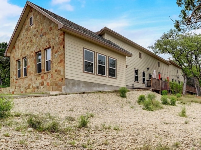 rear view of house featuring a wooden deck