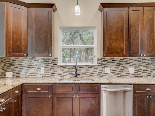 kitchen with tasteful backsplash, decorative light fixtures, sink, and stainless steel dishwasher