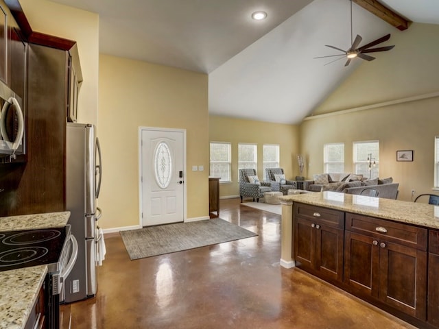 kitchen with stainless steel appliances, beam ceiling, ceiling fan, and light stone counters