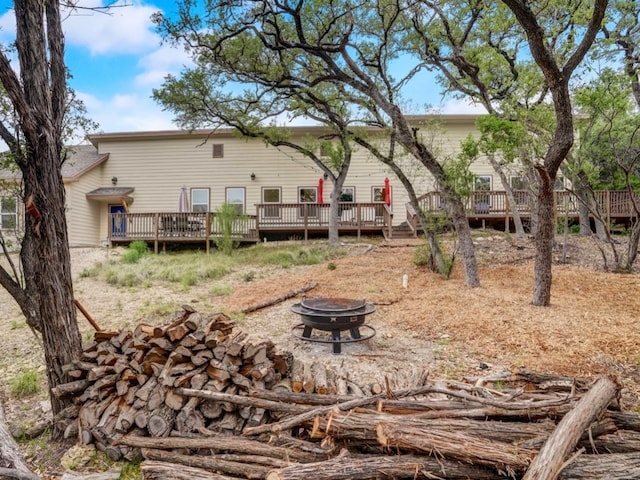 rear view of property with an outdoor fire pit and a deck