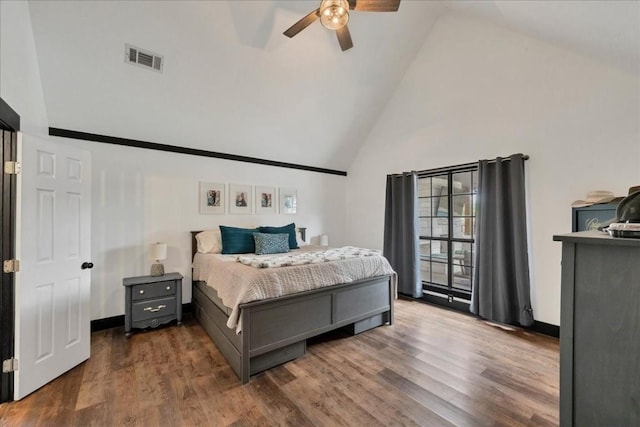 bedroom with ceiling fan, high vaulted ceiling, and dark wood-type flooring