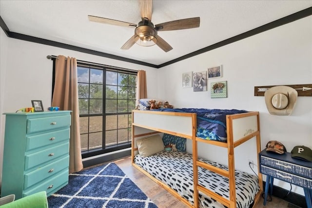 bedroom featuring dark hardwood / wood-style flooring, ceiling fan, and ornamental molding