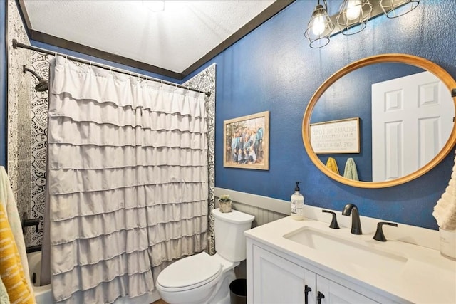 bathroom with vanity, toilet, and a textured ceiling