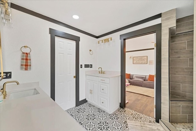 bathroom featuring crown molding, hardwood / wood-style floors, and vanity