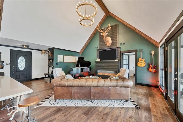 living room featuring a large fireplace, hardwood / wood-style floors, high vaulted ceiling, and a notable chandelier