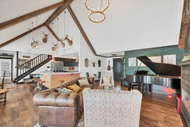 living room with ceiling fan with notable chandelier, beam ceiling, wood-type flooring, and high vaulted ceiling