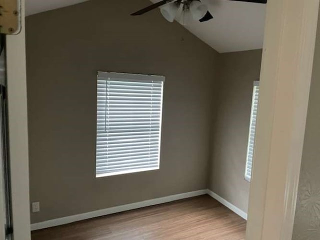 spare room featuring a healthy amount of sunlight, light hardwood / wood-style flooring, ceiling fan, and vaulted ceiling