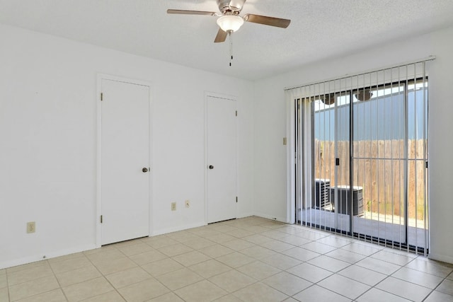 tiled empty room with a wealth of natural light, ceiling fan, and a textured ceiling